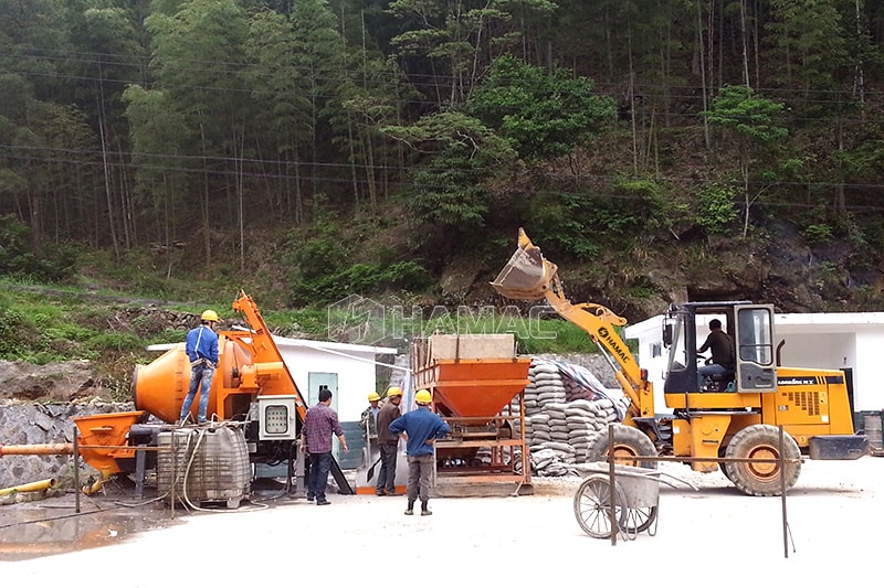Pompa beton mixer beroperasi dengan pemuat roda dan mesin pencampur agregat